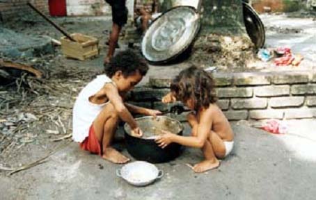 Niños rascando en una olla de comida en un país tercermundista.CRISTINA ARENAS