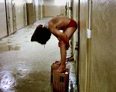 Prisionero iraquí, subido en unas cajas, encapuchado y maniatado en la cárcel. PAULA BAILE