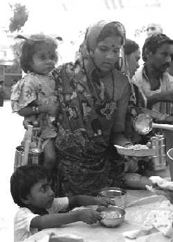 Una madre y su hija reciviendo de comer en Vrindavan, India. LAURA GRACIA